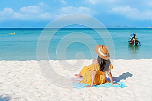 Happy traveler Asian woman on yellow dress relax on the tropical sandy beach. Summer, holiday concept. Free space