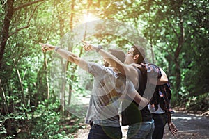 Happy traveler friends hugging and pointing something together at nature,Enjoying backpacking concept