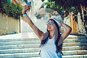 Happy traveler girl taking selfie photo on phone on Greek island of Symi, Dodecanese, Greece