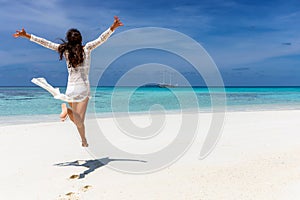 Happy traveler girl in white summer dress in the Maldives