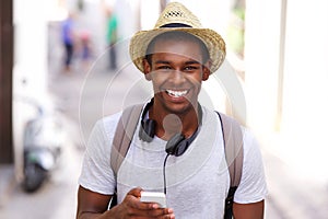 Happy traveler walking in town with mobile phone