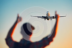 Happy traveler watching airplane landing