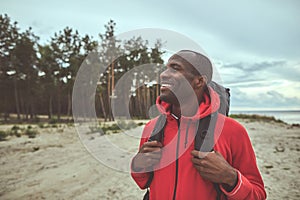 Happy traveler wearing backpack and looking around