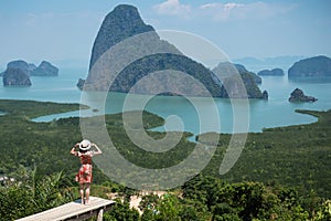 Happy traveler woman enjoy Phang Nga bay view point, alone Tourist standing and relaxing at Samet Nang She, near Phuket in