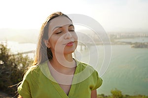 Happy traveler woman enjoying relaxed wind on face at sunset in her vacation in Brazil. Powerful and peaceful female aware of her