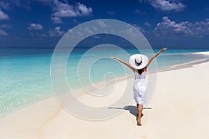 Happy traveler woman enjoys her summer vacation on a tropical beach