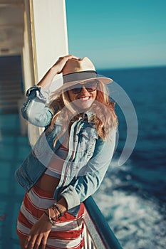 Happy traveler woman in hat toothy smile on cruise ship