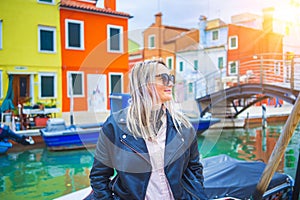 Happy traveler woman having fun near colorful houses on Burano island in Venetian lagoon. Travel and vacation in Italy