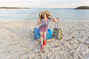 Happy traveler woman with suitcase on the beach. Concept of travel, journey, trip