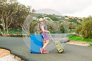 Happy traveler woman with suitcase on the beach. Concept of travel, journey, trip