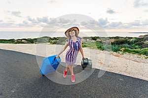 Happy traveler woman with suitcase on the road and laughs. Concept of travel, journey, trip