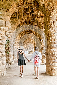 Happy traveler women tourists walking in famous Guell park in Barcelona