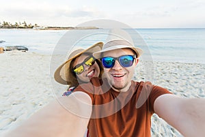 Happy traveling couple making selfie sea background , sunny summer colors, romantic mood. Stylish sunglasses, straw hat