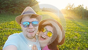 Happy traveling couple making selfie sunny summer colors at sunset