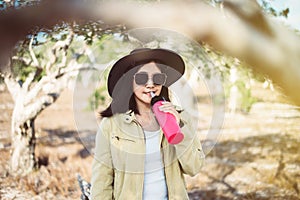 Happy traveller asian woman drinking water from the bottle in spending time at forest,Lifestyle travel outdoor concept