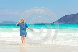 Šťastný cestovatel žena v modrý šaty má její tropický pláž 