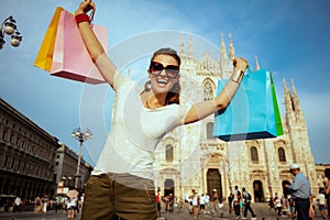 Happy traveller woman with colorful shopping bags rejoicing