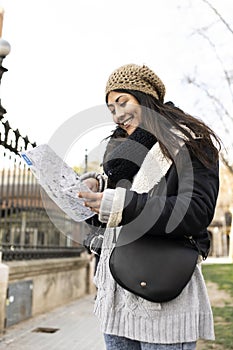 happy traveller woman looking a map outdoors. cheerful young female on vacations.