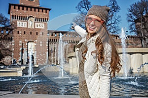 Happy traveller woman in Milan, Italy pointing at Sforza Castle