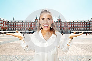 Happy traveller woman presenting something on empty palm