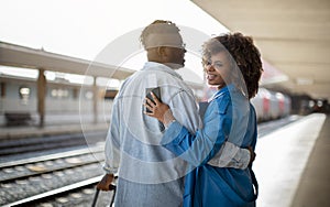 Happy Travellers. Portrait Of Young Black Couple Hugging At Railway Station