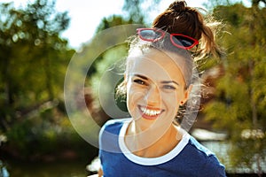 Happy trendy solo tourist woman on river boat river cruising