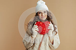 happy trendy woman in beige sweater, mittens and hat
