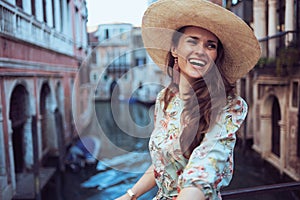 Happy trendy woman in floral dress exploring attractions