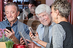 Happy Trio in Coffee House Using Electronic Devices