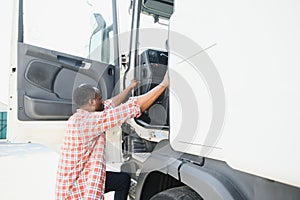 Happy truck driver entering in vehicle cabin.