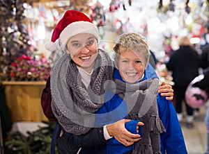Happy tween boy with mom during shopping at Christmas fair