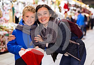 Happy tween boy with mom during shopping at Christmas fair