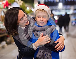 Happy tween boy with mom during shopping at Christmas fair