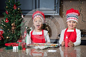Happy twin girls in red making Christmas cookies