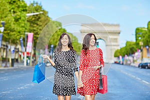 Happy twin sisters doing shopping on holidays in France