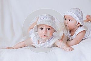 Happy twin sisters playing at home on a white background