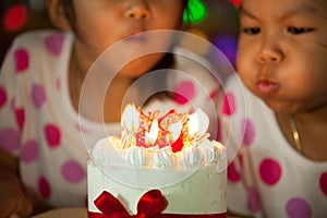 Happy twin two asian little girls celebrating birthday