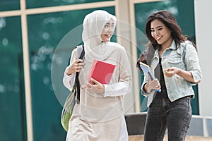 Two asian student walking on campus