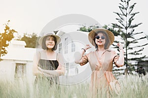 Happy two asian women standing in green garden at nature together,Outdoor portrait