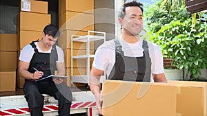 Happy two delivery men in front of delivery truck, Delivery men checking order of moving service