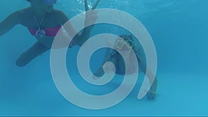 Happy Two Girls Dive In Swimming Pool look at the camera, Underwater Shoot