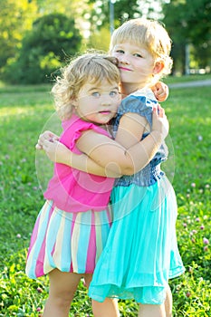 Happy two little sisters have a rest on the nature