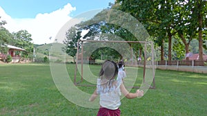 Happy two siblings girls having fun on the grass field in the park outdoor. Concept of Childhood happiness.