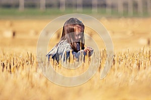 Happy two year old girl walking in a summer harvested field photo