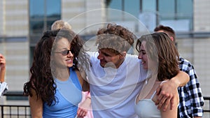 Happy two young women enjoying the party on the rooftop outdoors while dancing with their friends. Lifestyle, friendship
