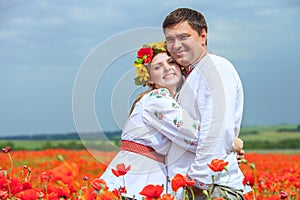 Happy ukrainian couple in blossom poppies field