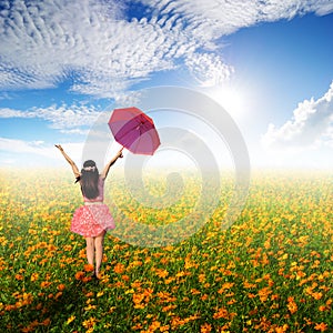 Happy umbrella woman jumping in flower garden and sun sky