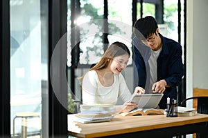 Happy university students discussing and collaborating on a project in class