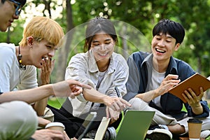 Happy university students doing group project together in university campus. Education and youth lifestyle concept