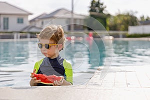 Happy vacation kid boy eat watermelon have fun enjoy at swimming pool. children cheerful activity relaxing in summer holiday